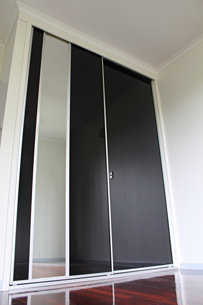 Polished Timber Floorboards, Black Glass Sliding Doors with insert mirror