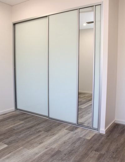 Bedroom Sliding Doors with white glass and mirror dress insert panel